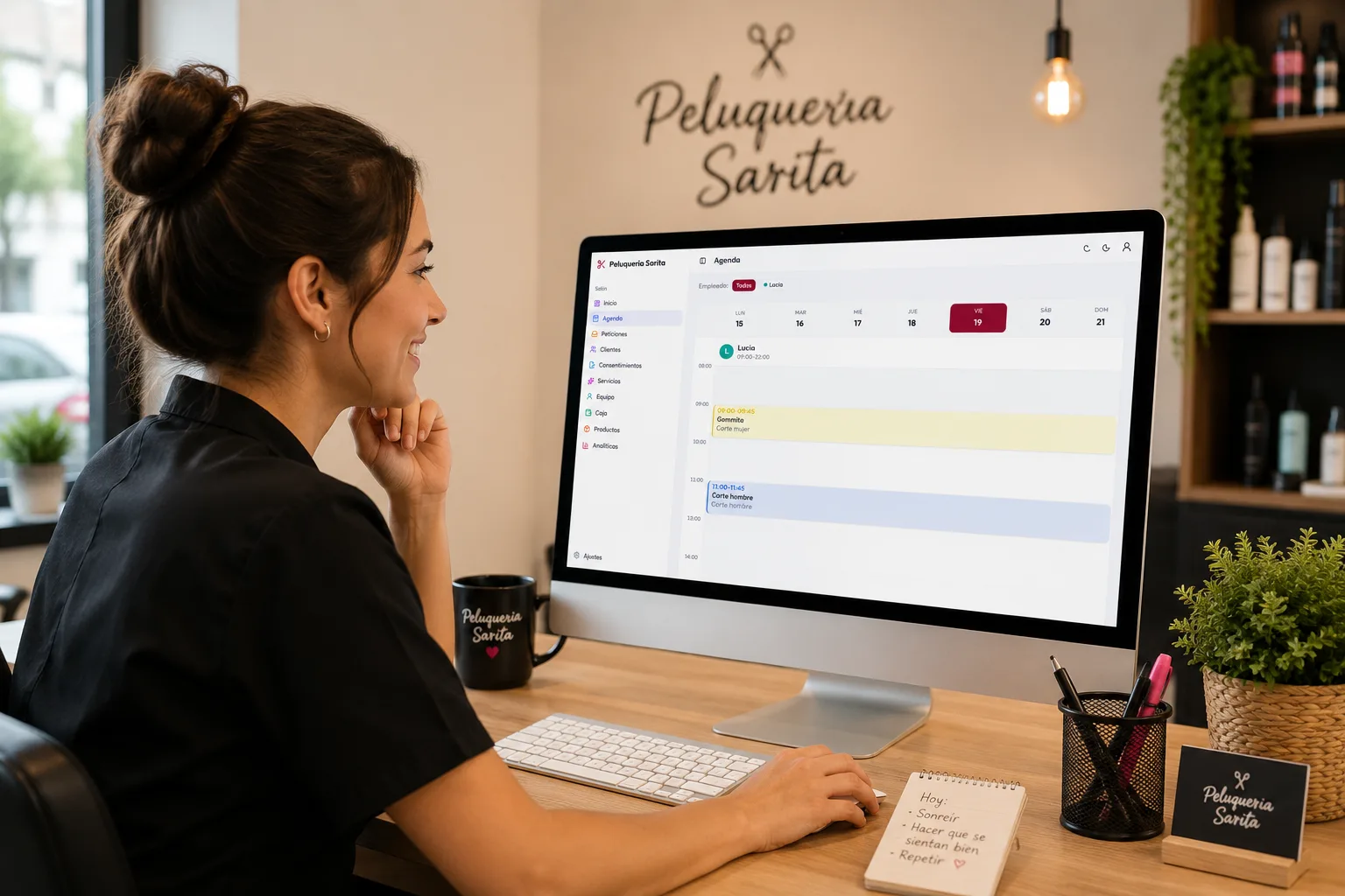 Profesional de una peluquería usando la agenda de Citalook en el ordenador de su salón